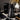 Black water bottle with measurement markings on a desk with a coffee cup and laptop.