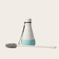 Silicone cleaning brush reaching through the Flask Vessel's narrow neck to the interior contours